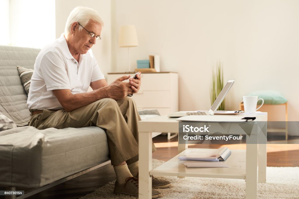 Senior hombre con Smartphone en casa - Foto de stock de Hombres mayores libre de derechos