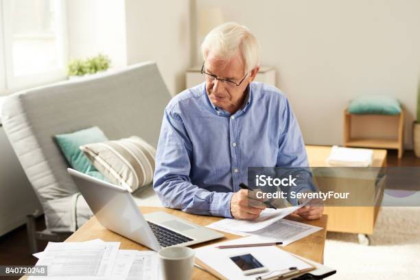 Senior Hombre Presentar Reporte De Impuestos En El País Foto de stock y más banco de imágenes de Tercera edad