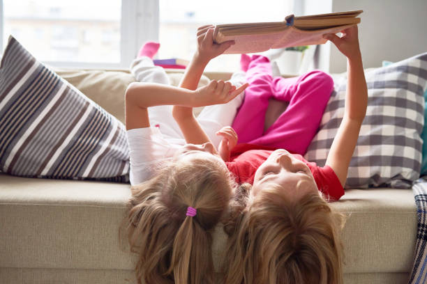 istock Little Girls Reading Book at Home 840733274