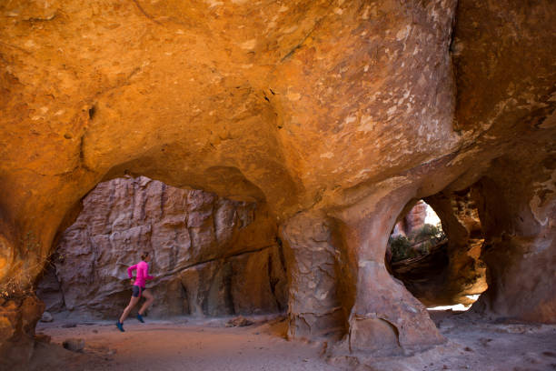 istock Female runs through a large cave 840750378
