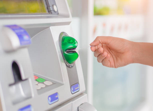 istock Close-up of woman's hand inserting debit card into an ATM machine. 840751524