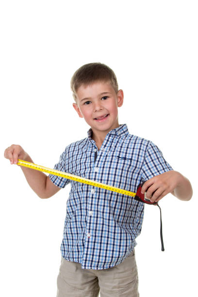 istock Young builder assistant in blue checkered shirt is happy to measure something with a measuring tape, white background. 840765318