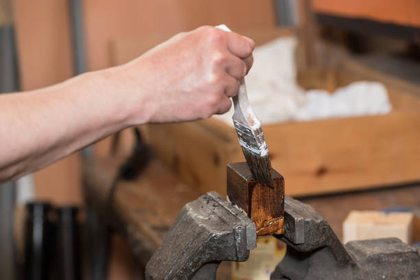 istock Man painting wooden workpiece 840774150