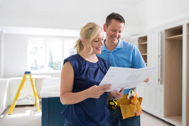 istock Woman With Carpenter Looking At Plans For New Kitchen 840774880