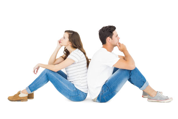Young japanese couple sitting back to back. White background.