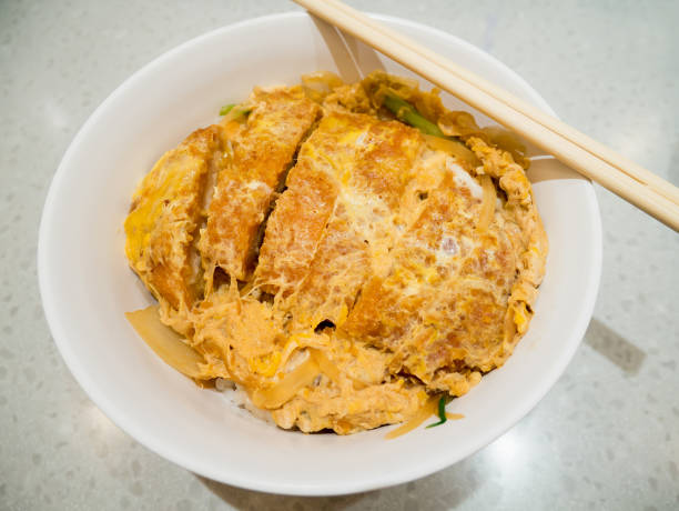 istock fried pork cutlet topped with egg on steamed rice in white bowl 840794610