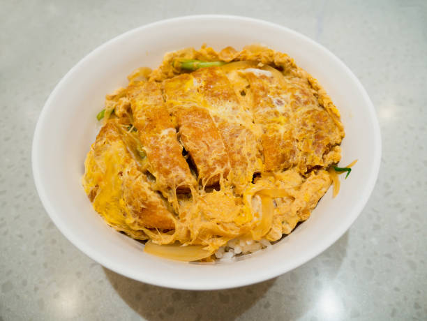 istock fried pork cutlet topped with egg on steamed rice in white bowl 840794616