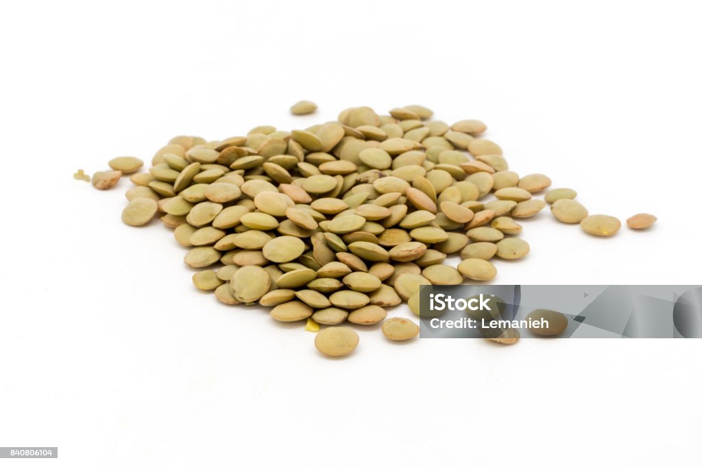Dried green lentils against a white background A studio isolated photograph of dries green lentils against a white background. Green Lentil Stock Photo