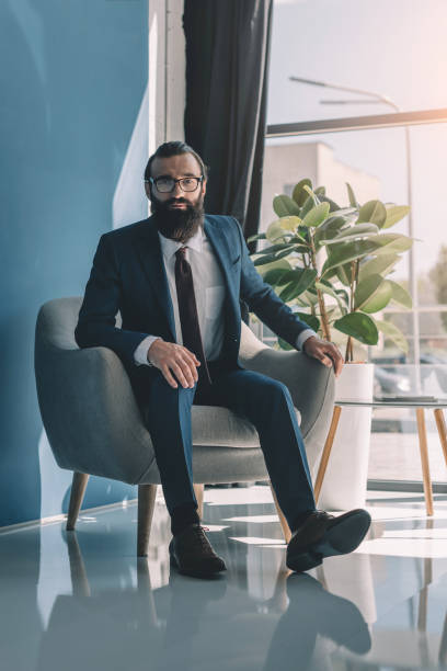 istock bearded businessman sitting in armchair 840810084