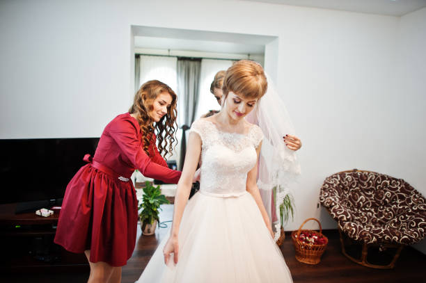 istock Beautiful bridesmiads help bride to get ready for her wedding ceremony. 840810942
