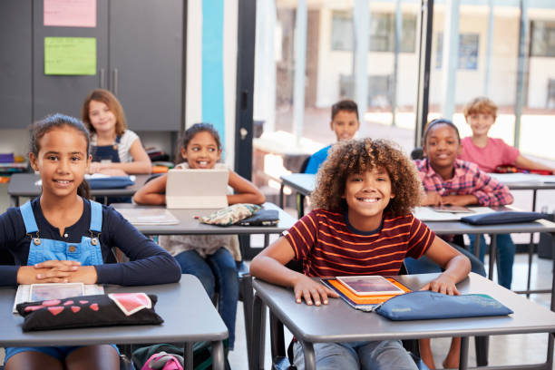 istock Portrait of elementary school pupils sitting at their desks 840813484