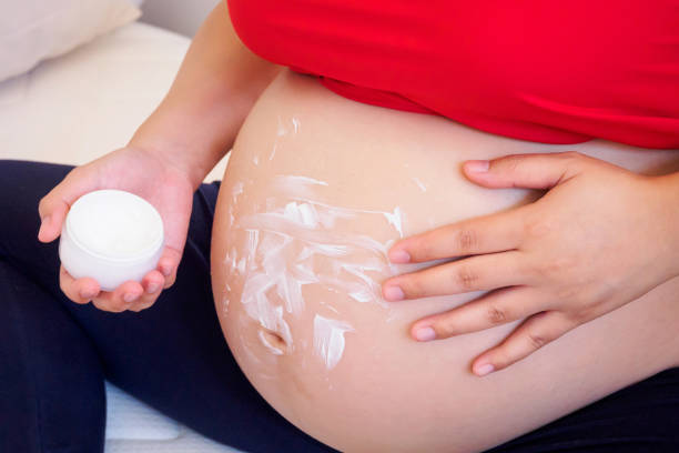 istock Pregnant Woman applying stretch marks cream on her belly 840813936