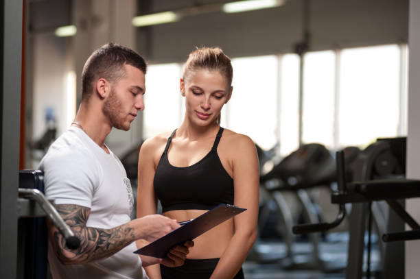 istock Personal trainer and his female client in gym 840814426