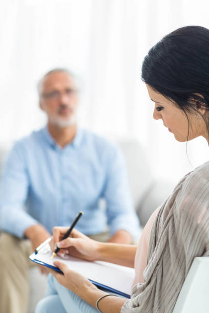 istock Female doctor writing on clipboard while consulting a man 840816020
