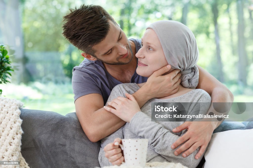 Supporting sick girlfriend in headscarf Sick girlfriend in headscarf after radiotherapy supported by loving boyfriend Cancer - Illness Stock Photo