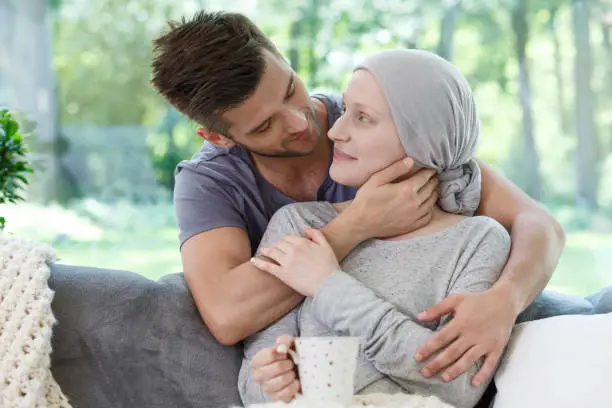 Sick girlfriend in headscarf after radiotherapy supported by loving boyfriend