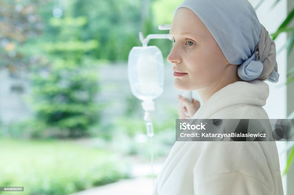 Young woman with skin cancer Young woman with skin cancer standing on a drip in hospital Cancer - Illness Stock Photo