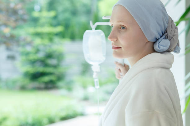 Young woman with skin cancer Young woman with skin cancer standing on a drip in hospital chemotherapy drug stock pictures, royalty-free photos & images