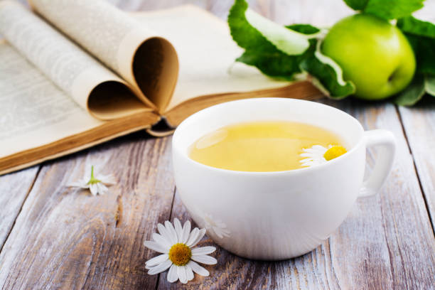 istock Cup of herbal tea and old book 840826370