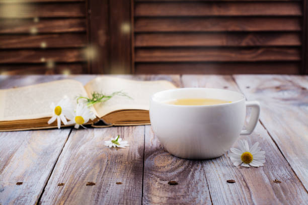 istock Cup of herbal tea and old book 840826450