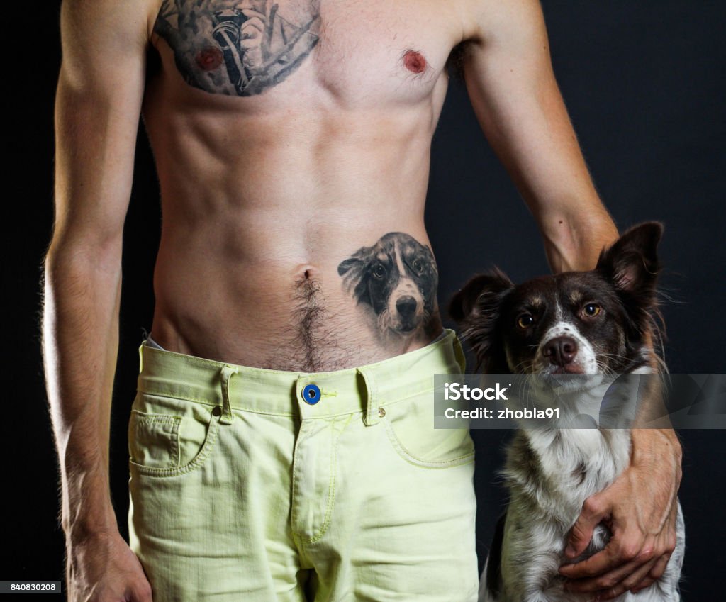 Man with tattoos and his dog Man, tattoo of his dog, and his dog Tattoo Stock Photo