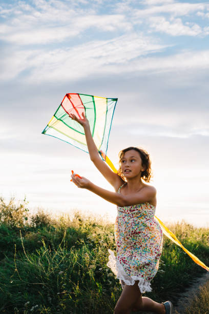 istock Girl holding kite and running in field 840830482