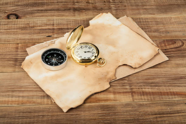 istock Two compasses and an old paper on a wooden table 840831388