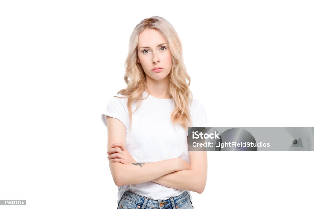 Young woman with arms crossed Half length shot of a young caucasian woman with arms crossed looking sad. Women Stock Photo
