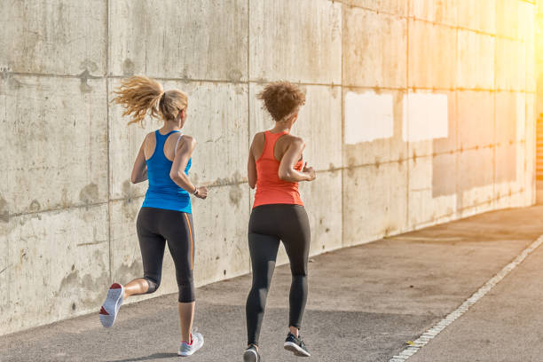 istock Two female athletes running together 840838862