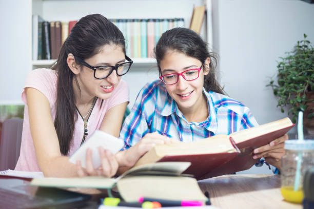 teenage girls studying science,using laptop and mobile phone - homework teenager mobile phone school imagens e fotografias de stock