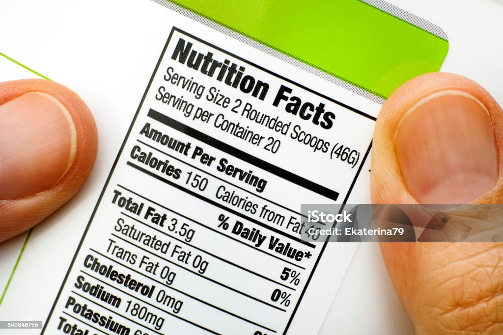 Woman fingers with protein jar. Reading nutrition facts Woman fingers with protein jar. Reading nutrition facts.  Close-up. Nutrition Label Stock Photo