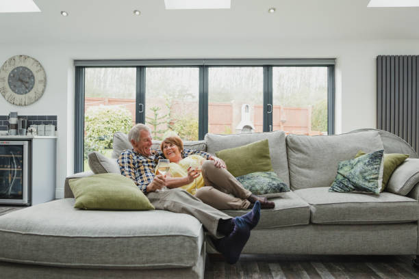 senior couple enjoying a glass at home - house residential structure uk contemporary imagens e fotografias de stock