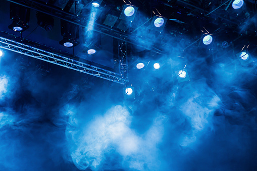 Azul los rayos de luz desde el foco a través del humo en la sala de teatro o concierto. Equipos de iluminación para una actuación o show photo