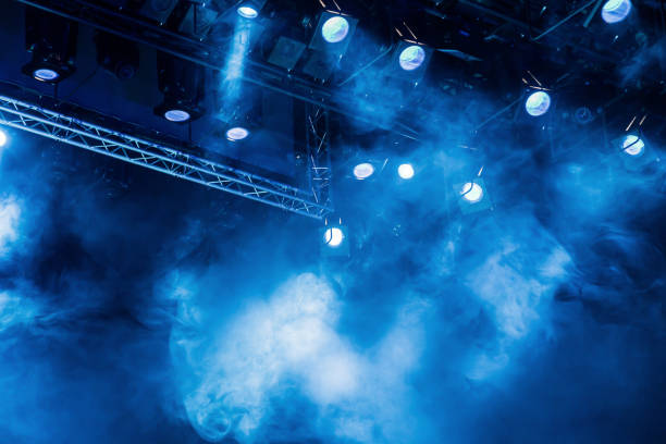 藍色光線透過煙霧在劇院或音樂會大廳聚光燈。照明設備演出或表演 - 煙霧 物理結構 圖片 個照片及圖片檔