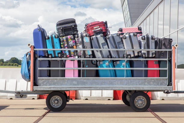 rimorchio in aeroporto pieno di valigie - baggage wagon foto e immagini stock