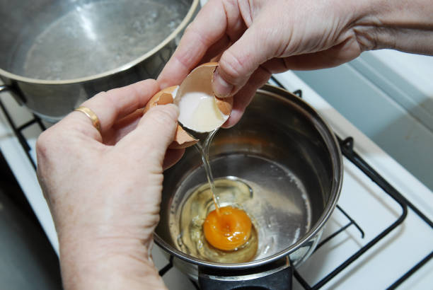 istock Hands breaking an egg. Raw egg pours into bowl. Key ingredient for tasty omelet. Fresh chicken egg. 840863486