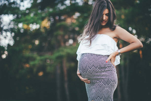 istock Smiling pregnant woman in a park 840866070