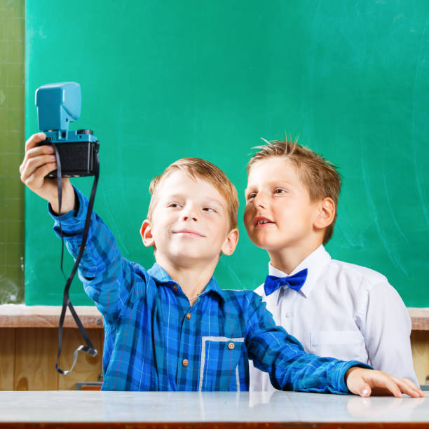 istock Two schoolboys make selfie at blackboard in school 840866260