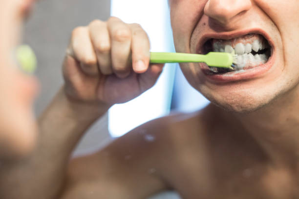 young adult se brosser les dents - hairbrush photos et images de collection