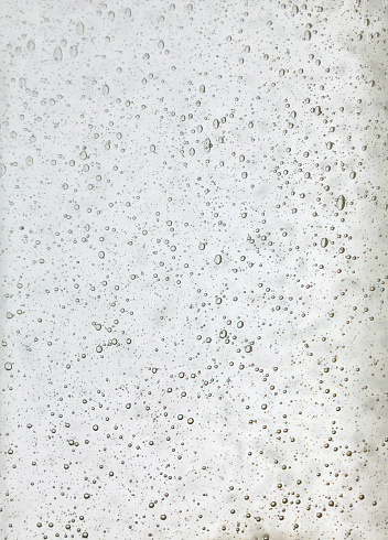Background texture of solid transparent white glass with pattern of air bubbles, close up