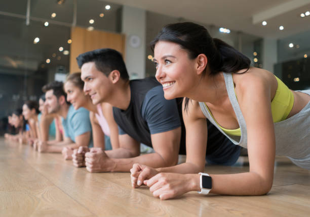 istock Group of people exercising at the gym doing planks 840874884