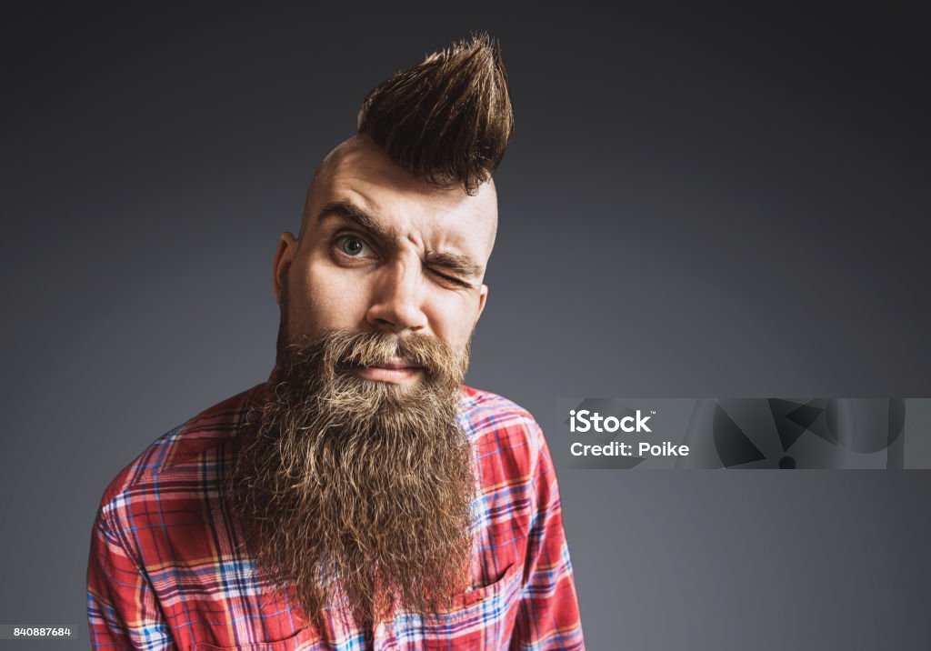 Young trendy punk man portrait Young punk rocker man looking at camera. Isolated on gray background Bizarre Stock Photo