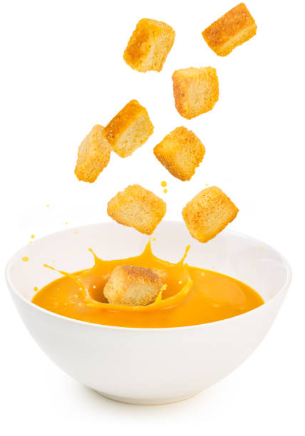 croutons falling into a soup bowl stock photo