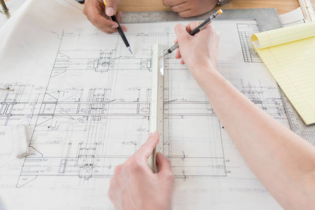 istock Two sets of hands work opposite each other on a blueprint 840890202