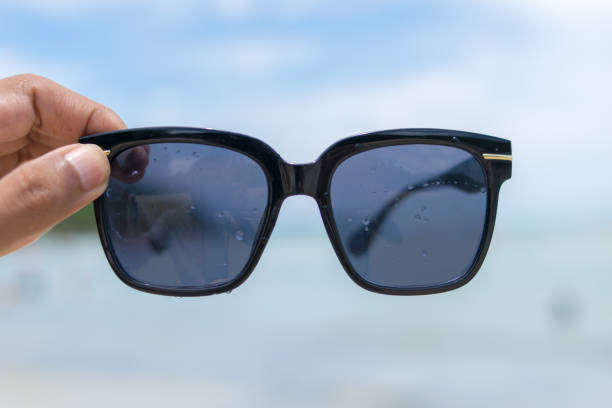 istock hand holding sunglasses on the beach 840891082