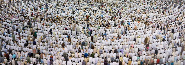 A huge amount of people in one place Thousands of crowded people standing together in circle order lines praying in The Holdy Mosque in Mecca, Saudi Arabia kaabah stock pictures, royalty-free photos & images