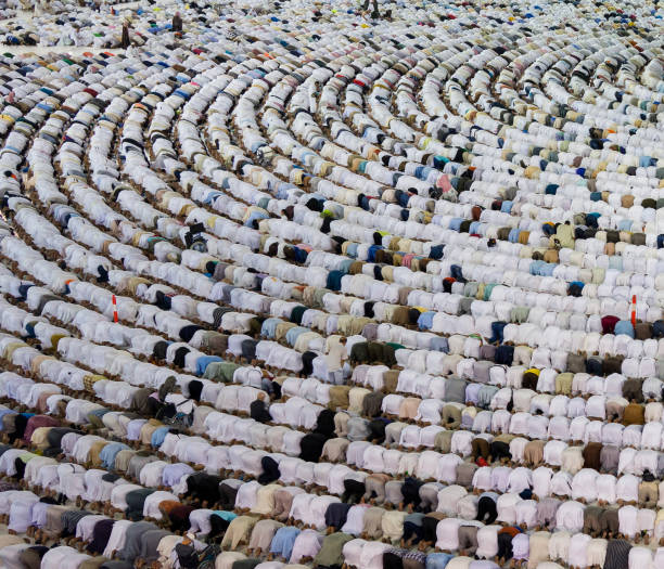 A huge amount of people in one place Thousands of crowded people standing together in circle order lines praying in The Holdy Mosque in Mecca, Saudi Arabia kaabah stock pictures, royalty-free photos & images