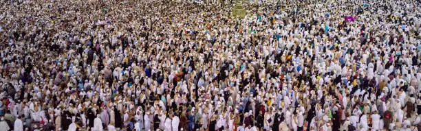 Thousands of crowded people standing together in circle order lines praying in The Holdy Mosque in Mecca, Saudi Arabia