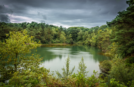 Landscape Of A Site Of Special Scientific Interest, The Blue Pool, Set In A Deep Clay Bowl, Very Fine Clay In Suspension In The Water Diffracts Light In Different Ways, Producing A Spectrum Of Green And Turquoise.