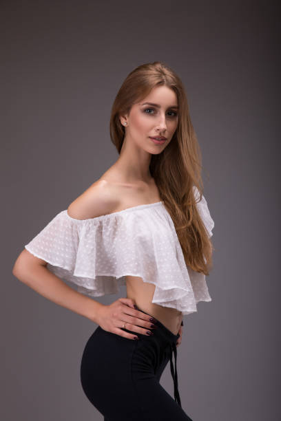 istock attractive woman in white blouse posing over gray background 840898780